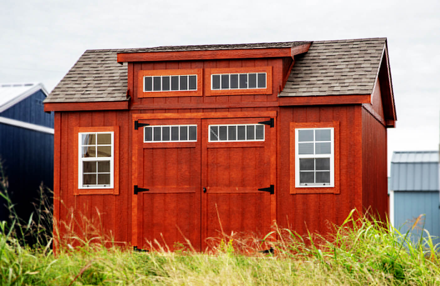 Chalet style outdoor storage shed with a peaked roof and wood paneling, providing a functional and stylish storage