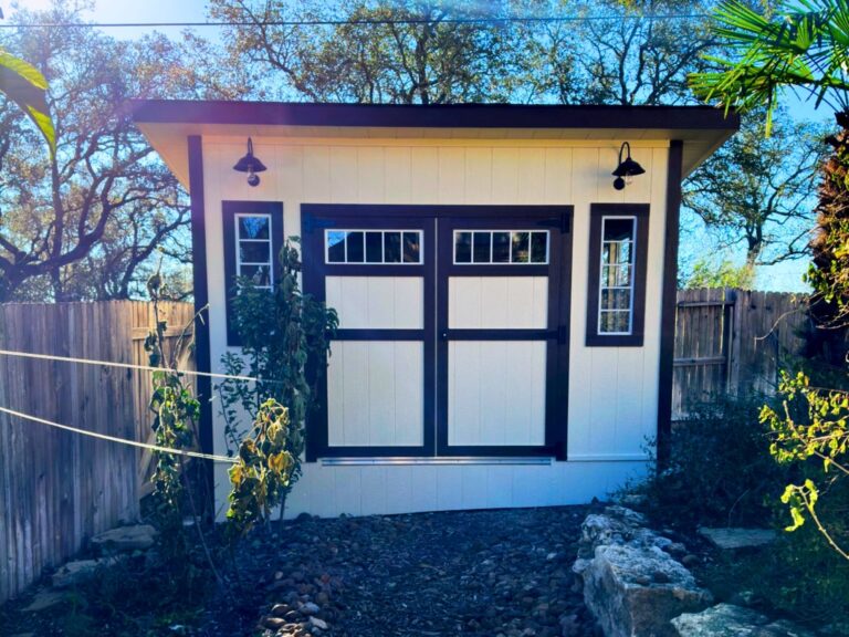 Spacious white outdoor storage shed with double doors and built-in shelving for organization