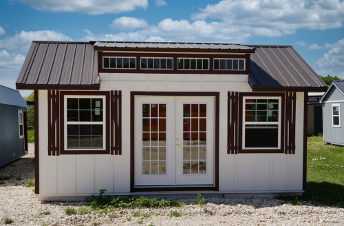 Stunning white chalet with a beautiful brown roof and dormer, nestled in a picturesque outdoor setting.