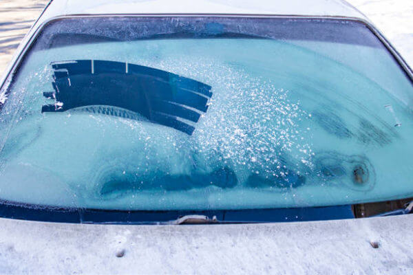 Icy car windows because the garage is occupied, emphasize the need for a storage solution like a lelands barns shed